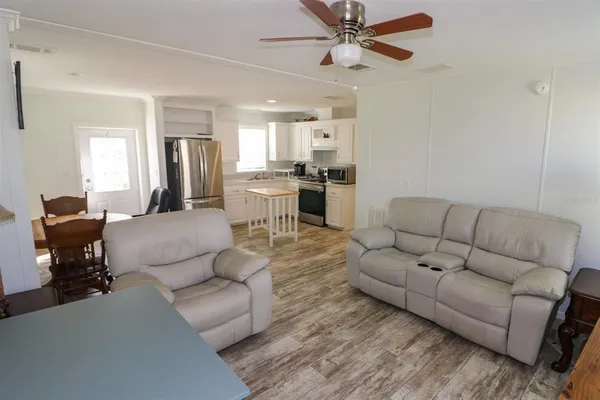 a living room with furniture and a view of kitchen
