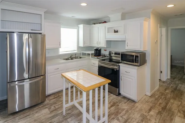 a kitchen with stainless steel appliances granite countertop a refrigerator a stove a sink and a refrigerator