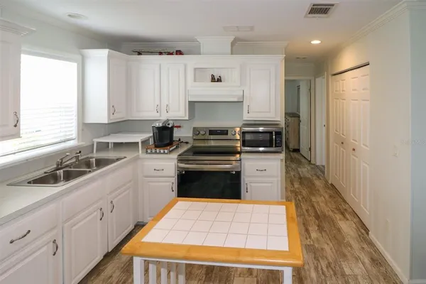 a kitchen with white cabinets and appliances