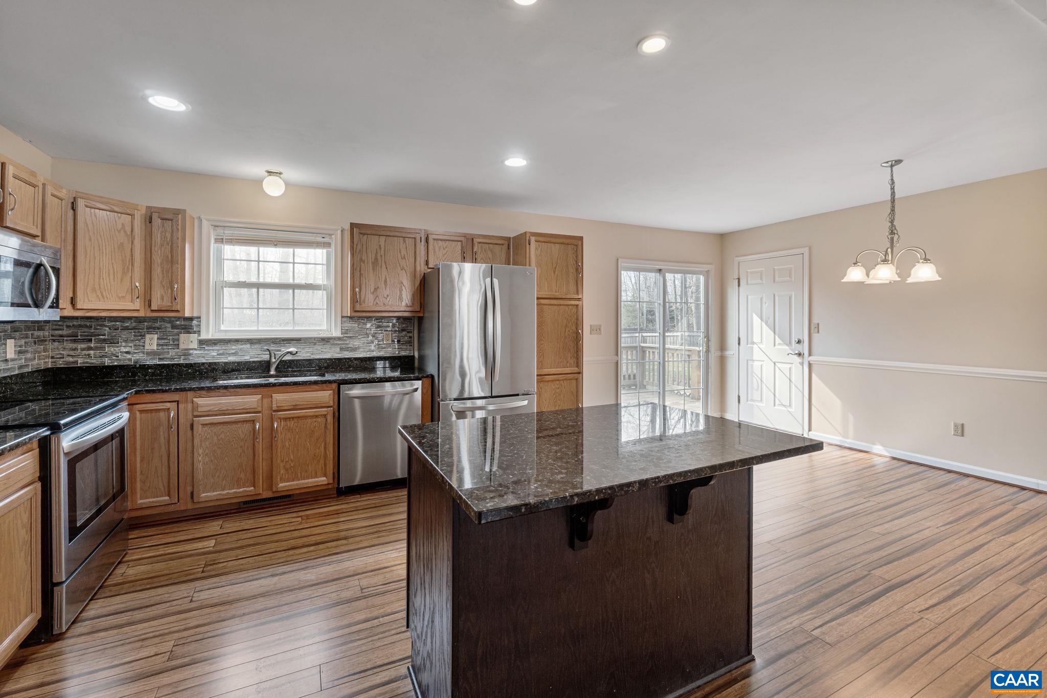 7 Riverside Drive Palmyra, VA 22963 - Photo 9 of 26 a kitchen with granite countertop a stove a sink dishwasher a refrigerator and white cabinets with wooden floor