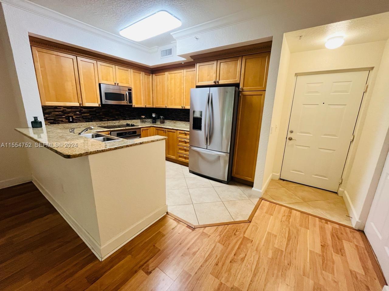 a kitchen with stainless steel appliances a refrigerator sink and microwave