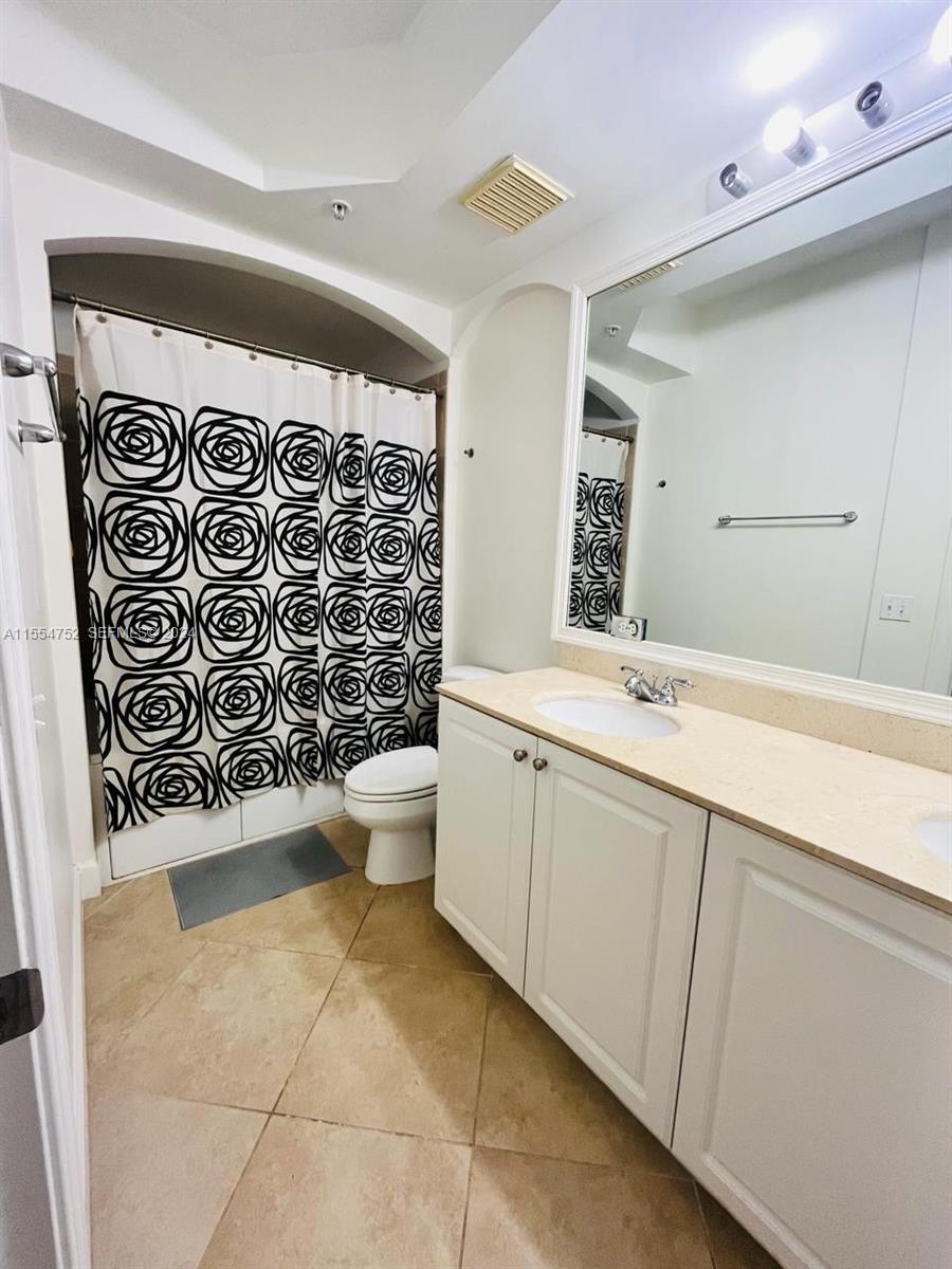 1121 Renaissance Way, Unit 1121 Boynton Beach, FL 33426 - Photo 13 of 26 a bathroom with a toilet sink and mirror