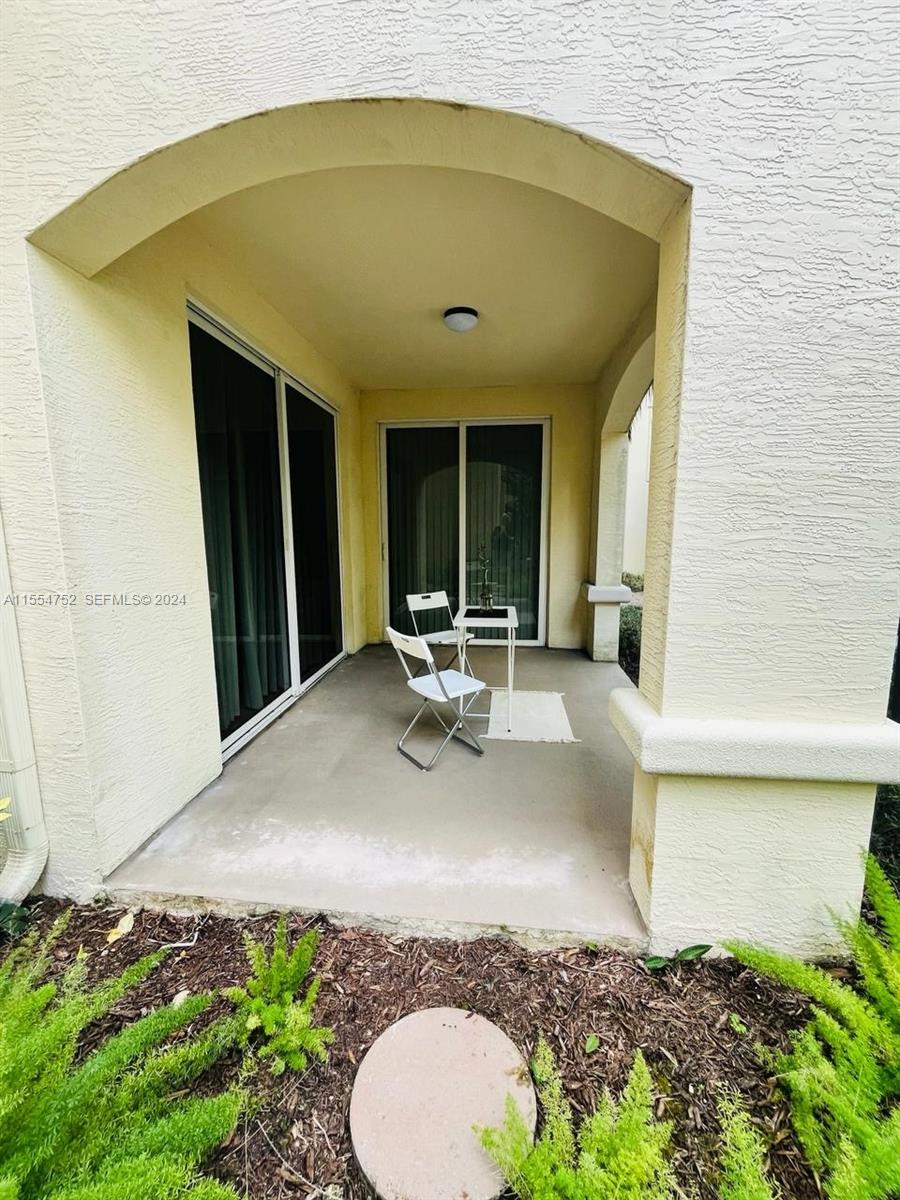 1121 Renaissance Way, Unit 1121 Boynton Beach, FL 33426 - Photo 26 of 26 a view of a patio with table and chairs potted plants with wooden floor