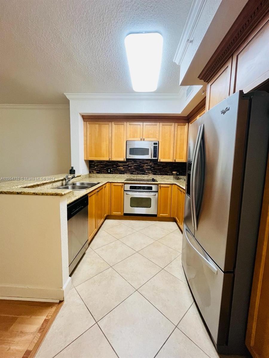 1121 Renaissance Way, Unit 1121 Boynton Beach, FL 33426 - Photo 3 of 26 a kitchen with stainless steel appliances granite countertop a stove a sink and a refrigerator