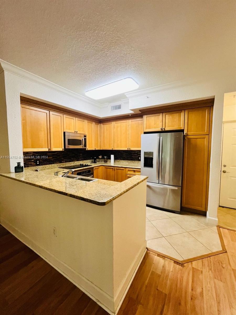 1121 Renaissance Way, Unit 1121 Boynton Beach, FL 33426 - Photo 5 of 26 a kitchen with stainless steel appliances granite countertop a stove a sink and a refrigerator