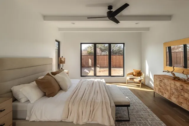 a bedroom with a bed a couch and a large window