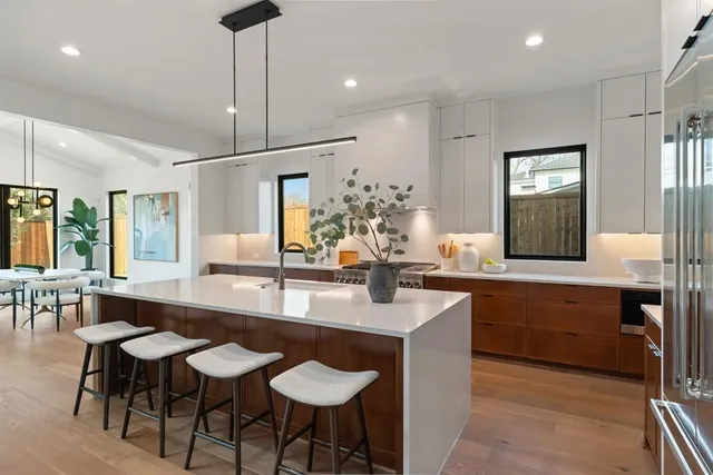 a large kitchen with kitchen island a table and chairs in it
