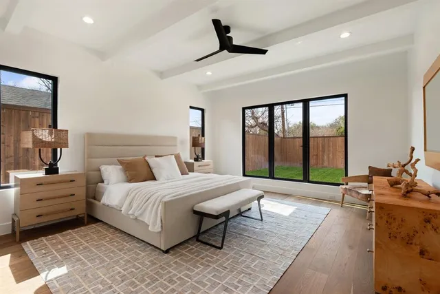 a spacious bedroom with a bed a couch and a large window