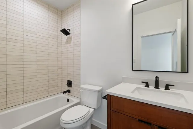 a bathroom with a sink toilet vanity and shower