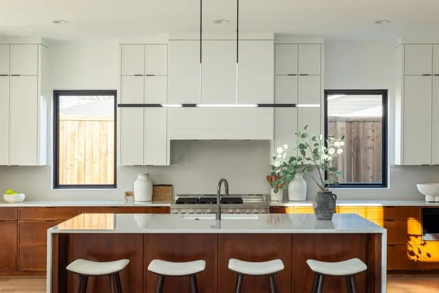 a kitchen with granite countertop a sink and white cabinets