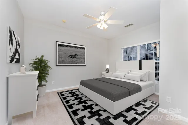 a bedroom with a large bed and a chandelier