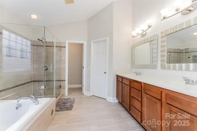 a bathroom with a tub sink shower and mirror