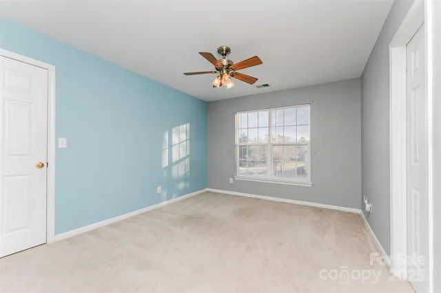 a view of a livingroom with a ceiling fan and window