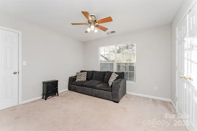 a living room with furniture and a ceiling fan