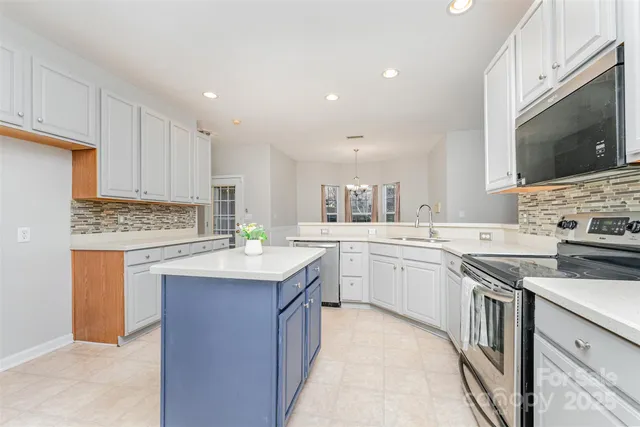 a kitchen with granite countertop a sink stove top oven and microwave