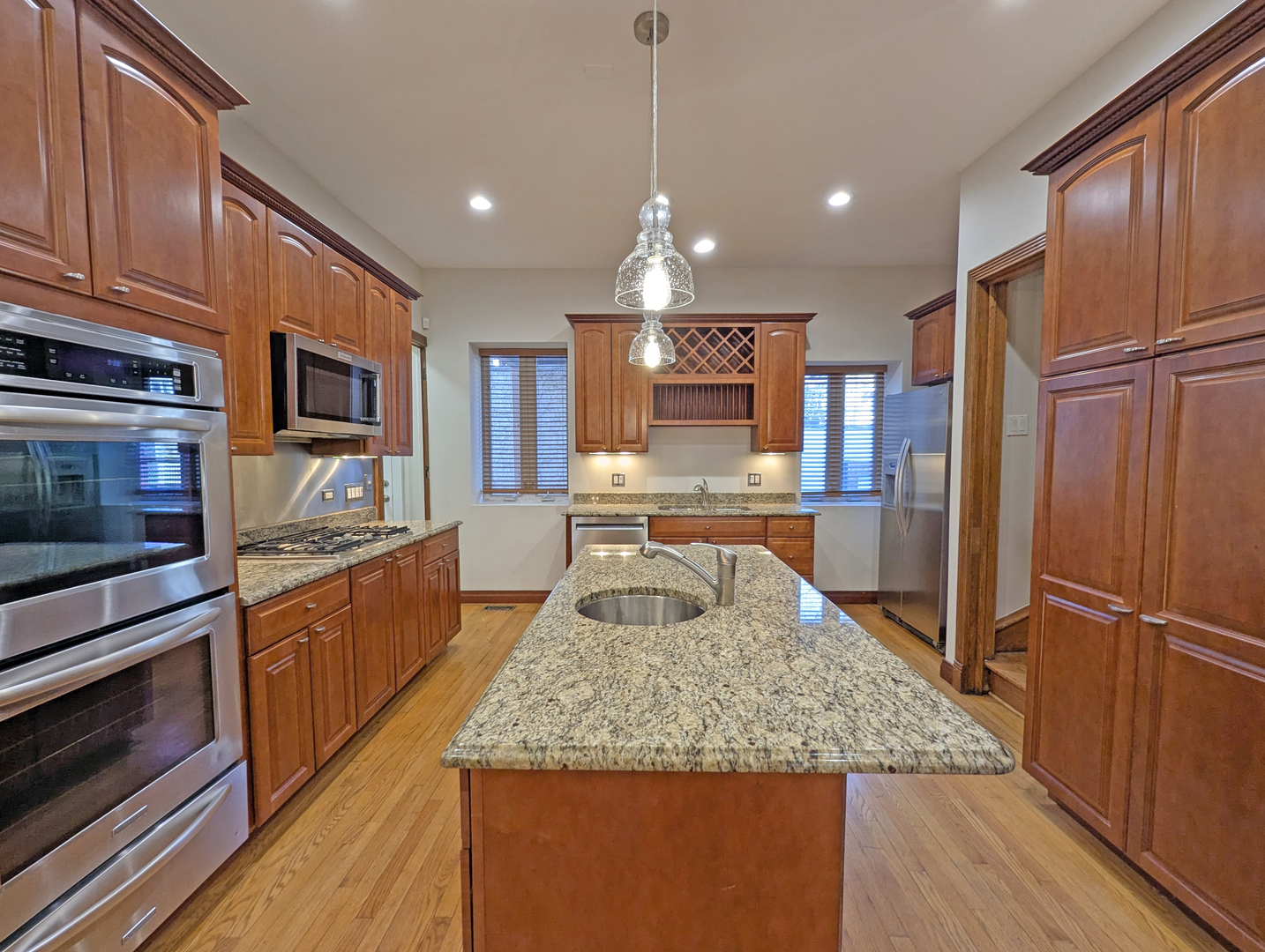 836 East 52nd Street Chicago, IL 60615 - Photo 16 of 43 a kitchen with stainless steel appliances granite countertop wooden cabinets a refrigerator and a sink