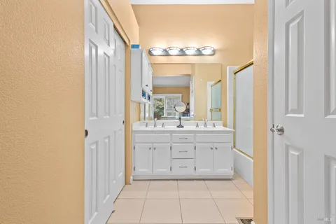 a bathroom with a double vanity sink and a mirror