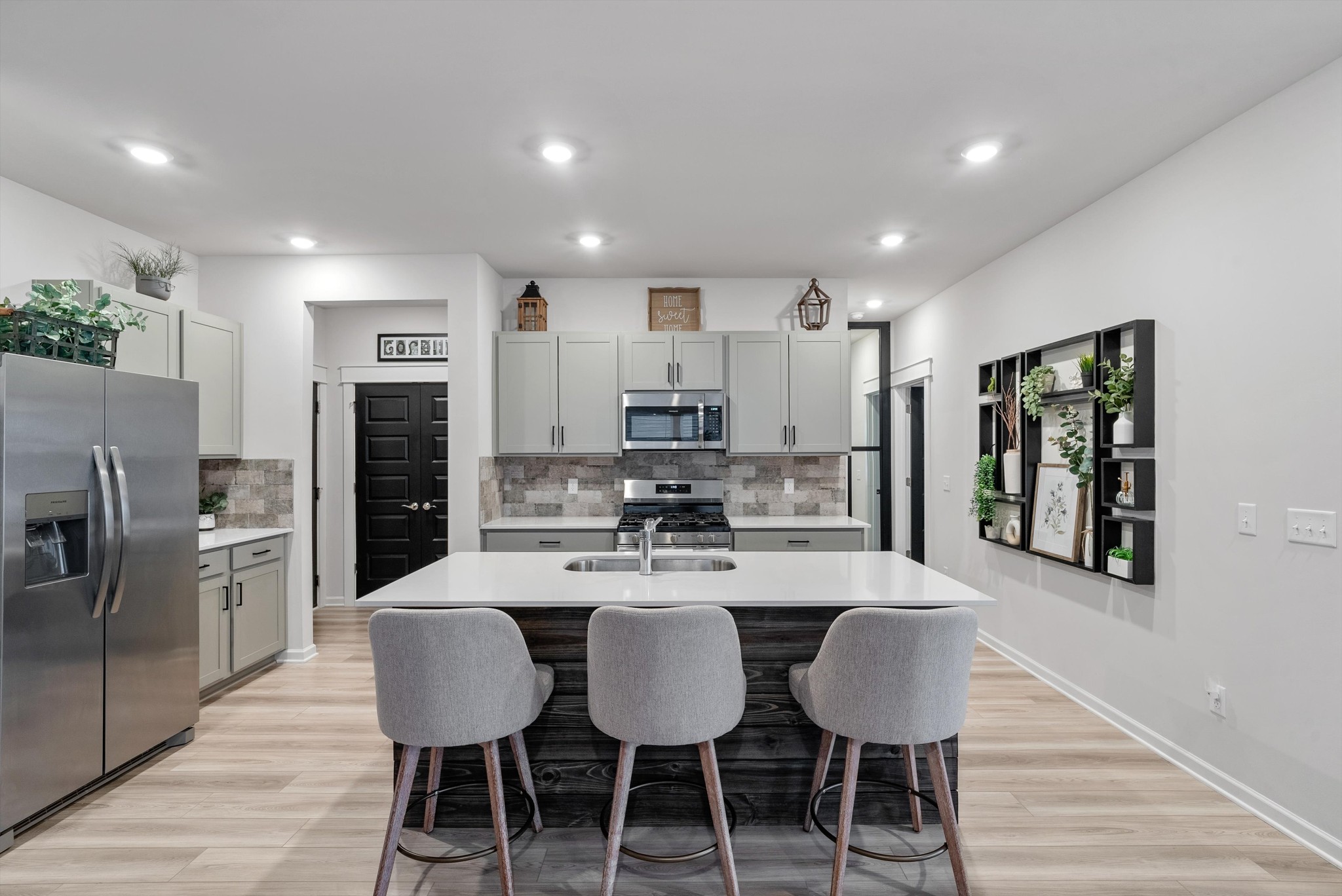 562 Torrey Pines Lane Lebanon, TN 37087 - Photo 8 of 38 a kitchen with stainless steel appliances kitchen island granite countertop a dining table chairs refrigerator and microwave