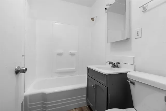 a bathroom with a sink toilet vanity and bathtub