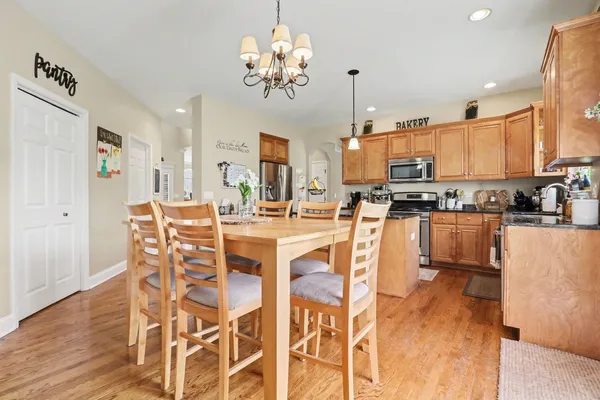 a kitchen with stainless steel appliances kitchen island granite countertop a dining table chairs and granite counter tops