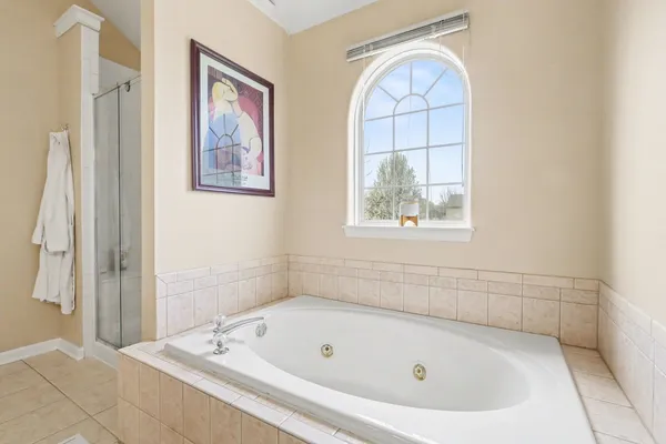 a bathroom with a tub and a large window