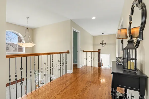 a view of staircase with railing and a chandelier