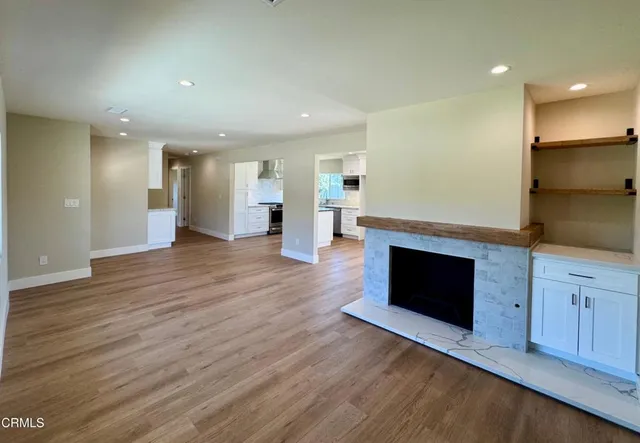 an empty room with wooden floor and fireplace