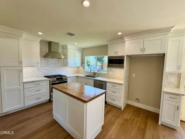 a kitchen with granite countertop white cabinets and white appliances