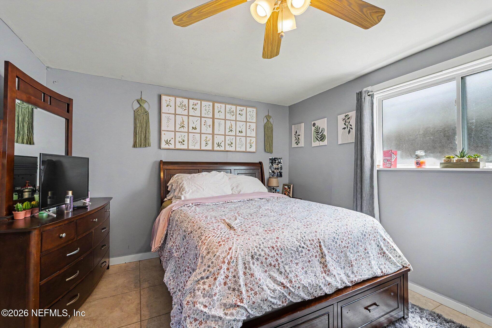 3500 Roosevelt Road Mims, FL 32754 - Photo 16 of 30 a bedroom with a bed and a flat tv screen on the dresser