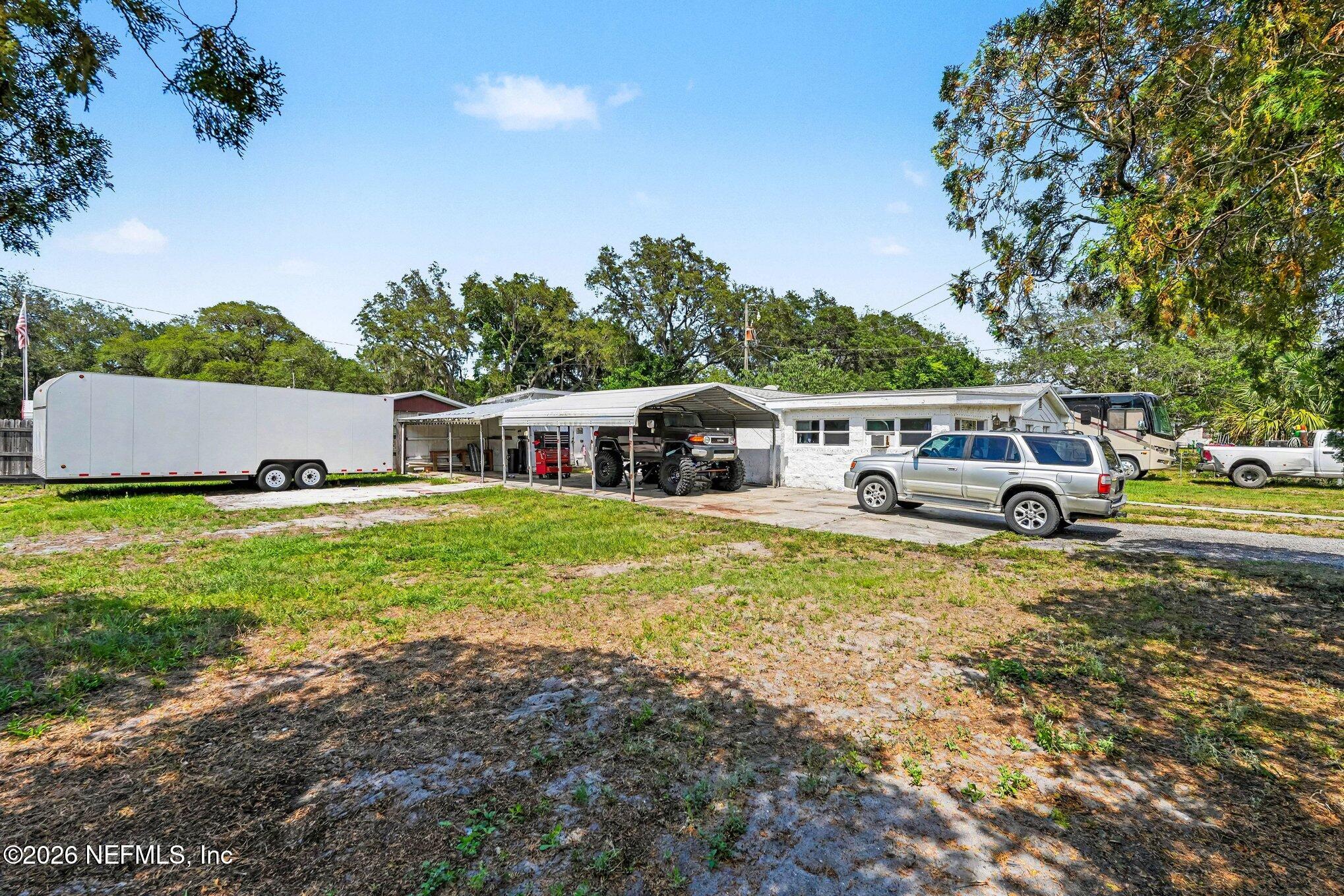 3500 Roosevelt Road Mims, FL 32754 - Photo 4 of 30 a front view of a house with a garden and trees