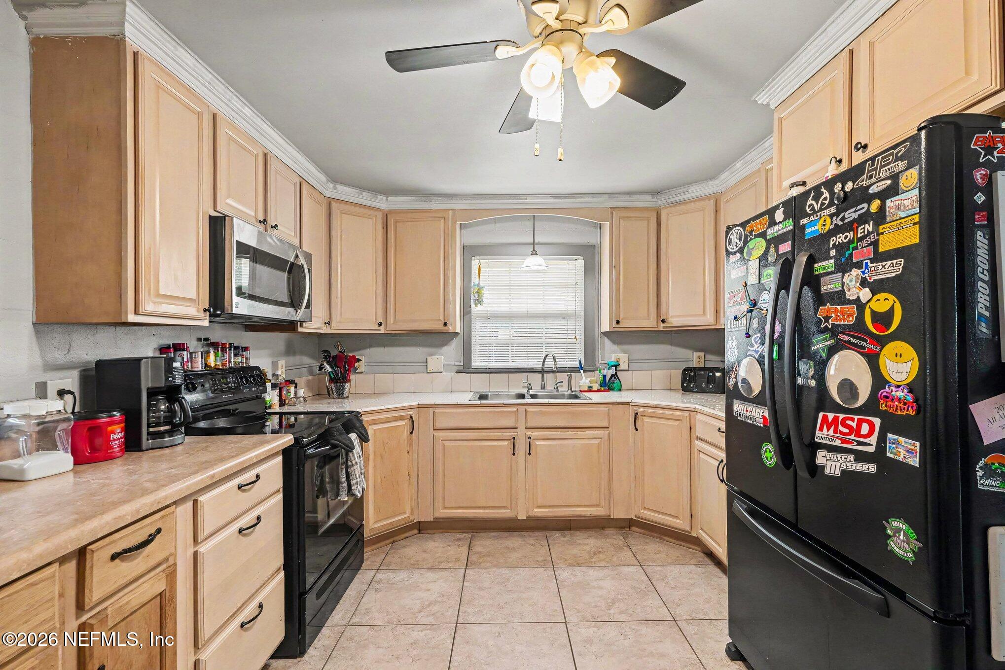 3500 Roosevelt Road Mims, FL 32754 - Photo 10 of 30 a kitchen with stainless steel appliances granite countertop a stove a sink and a microwave
