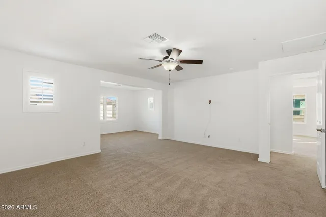 a view of an empty room with a ceiling fan