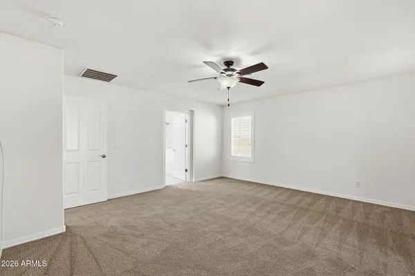 a view of an empty room with a ceiling fan