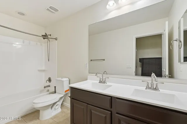 a bathroom with a double vanity sink toilet mirror and shower