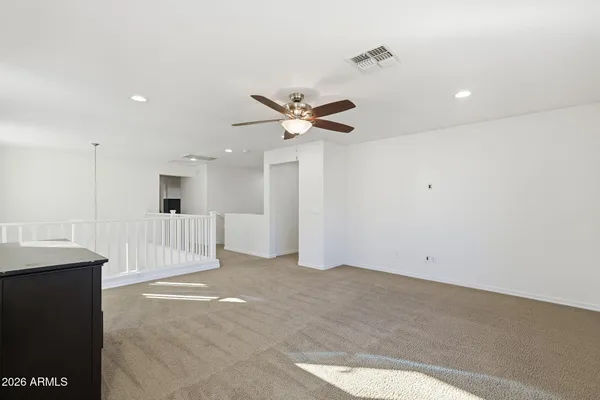 a view of an empty room with a ceiling fan