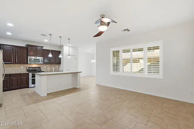 a large kitchen with kitchen island a large counter top stainless steel appliances and cabinets