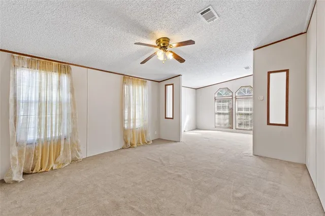 a view of a livingroom with a ceiling fan and window