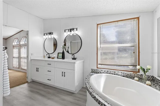 a bathroom with a tub sink and mirror
