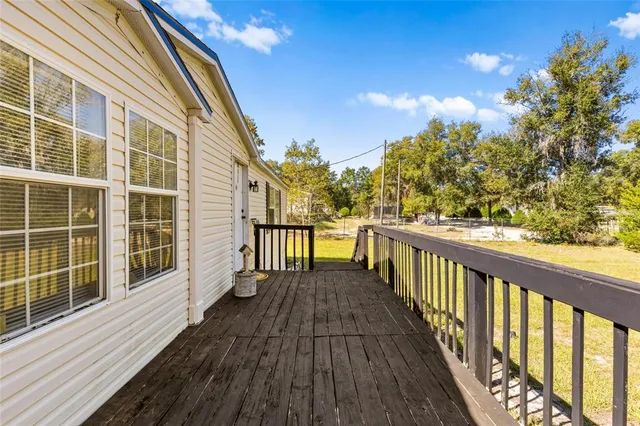 a view of a balcony with wooden floor and fence