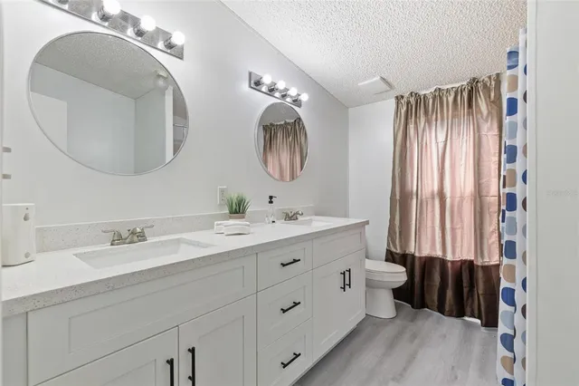 a spacious bathroom with a double vanity sink double mirror and a toilet