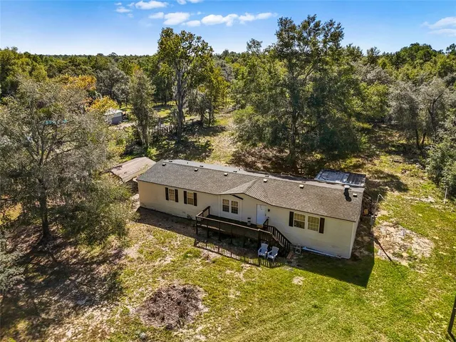 an aerial view of a house with a big yard