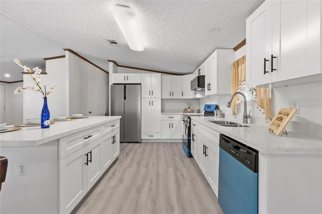 a large kitchen with stainless steel appliances lots of counter space and wooden floor