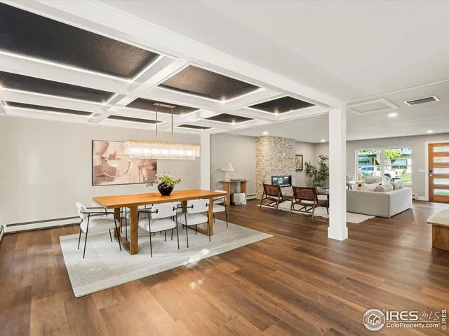 a dining room with wooden floor a table and chairs