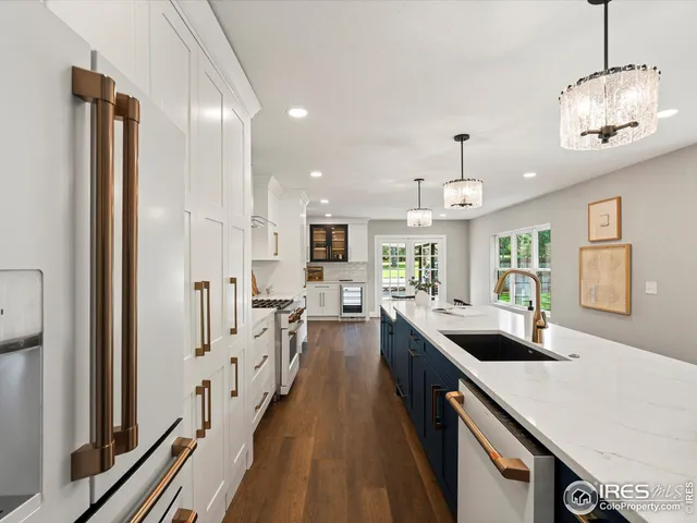 a very nice looking kitchen with granite countertop a large counter top appliances and cabinets