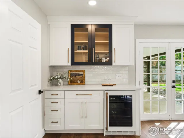 a kitchen with white cabinets and window