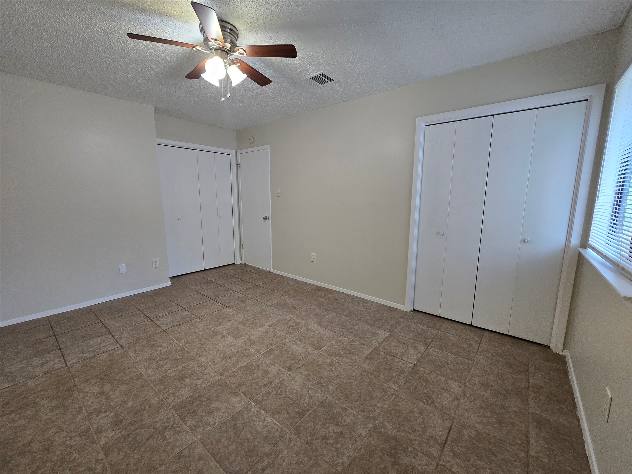 6206 Buffalo Pass, Unit A Austin, TX 78745 - Photo 14 of 24 A quiet bedroom featuring practical tile flooring and convenient closets for organized living.