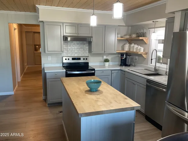 a kitchen with stainless steel appliances granite countertop a sink a stove and a refrigerator