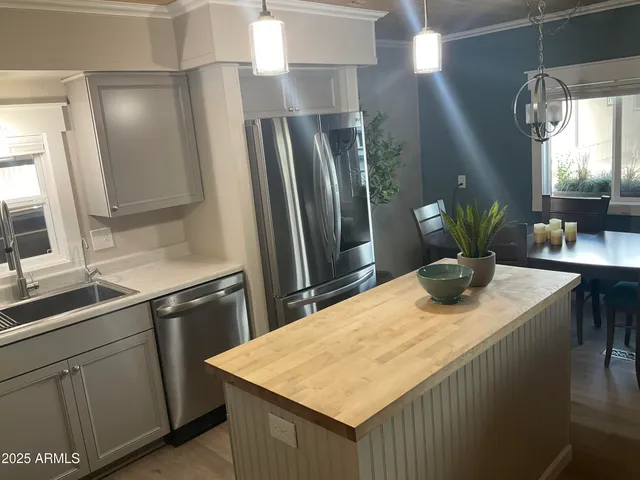 a kitchen with stainless steel appliances kitchen island a refrigerator sink and stove