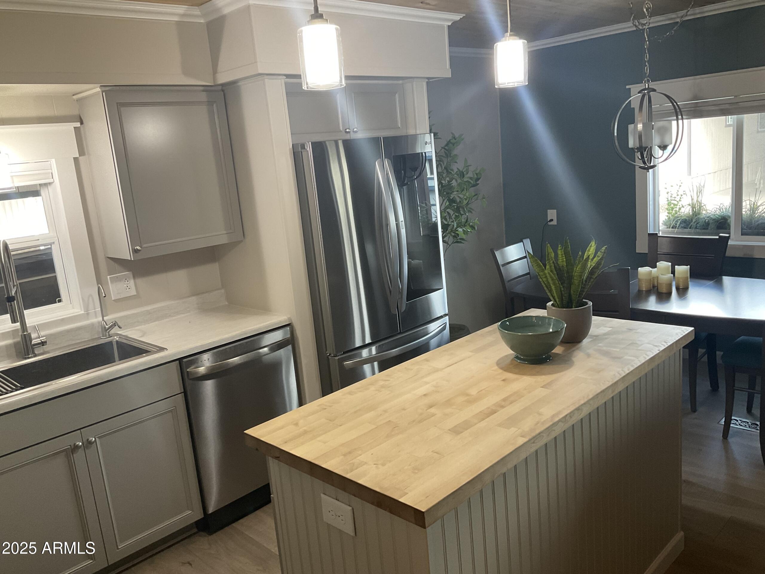 2175 West Southern Avenue, Unit 203 Apache Junction, AZ 85120 - Photo 6 of 28 a kitchen with stainless steel appliances kitchen island a refrigerator sink and stove
