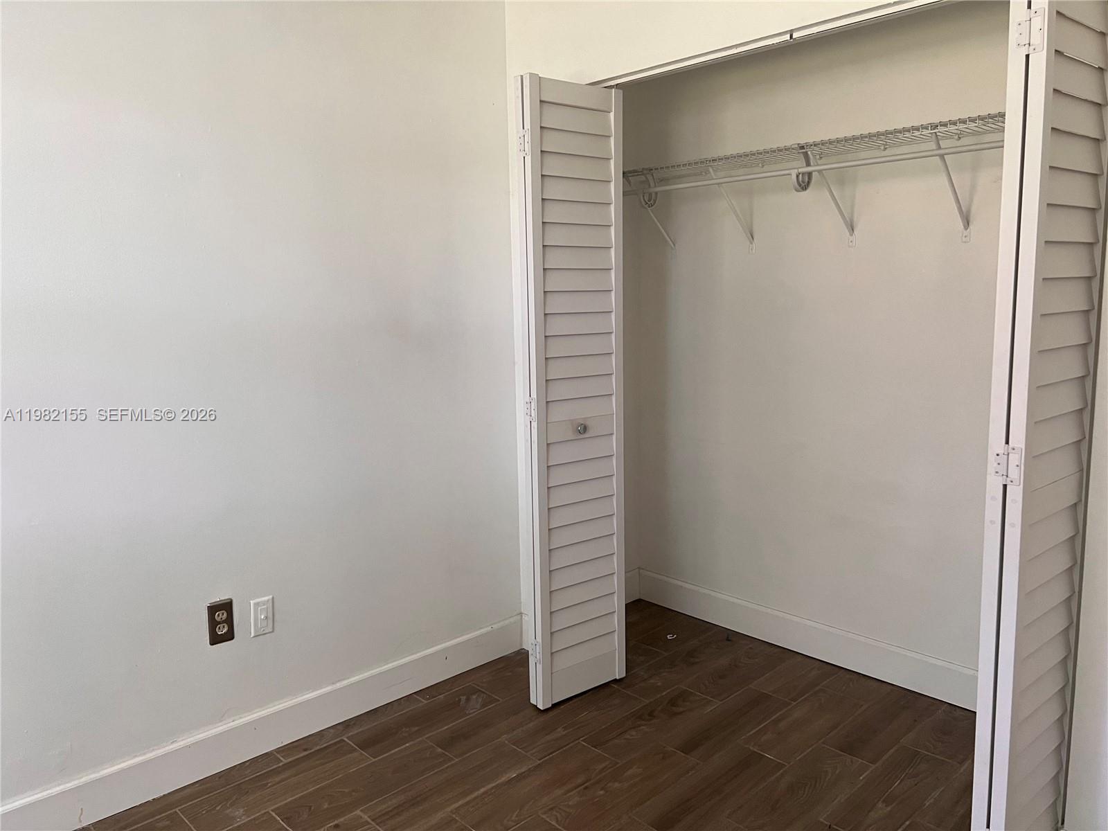 15610 Southwest 80th Street, Unit J105 Miami, FL 33193 - Photo 12 of 38 a view of an empty room with wooden floor and a window